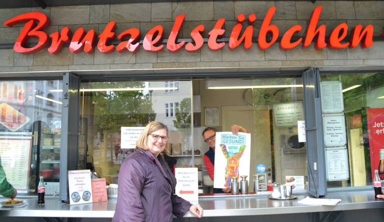 Bezirksbürgermeisterin Angelika Schöttler bei der Plakataktion vor dem Brutzelstübchen. Foto: Wirtschaftsförderung
