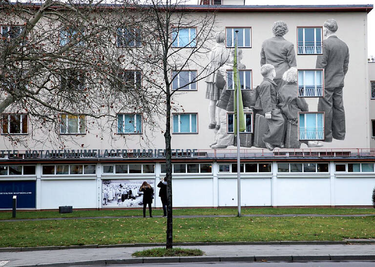 Familie im Notaufnahmelager – Geschichte, fest mit Marienfelde verbunden. Illustration: Oliver Schulz / Bezirksamt Tempelhof-Schöneberg