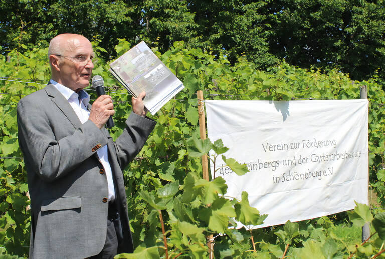 Der ehemalige Bezirksbürgermeister von Schöneberg, Michael Barthel, mit der Broschüre zum 100-jährigen Jubiläum der Gartenarbeitsschule. Foto: Pressestelle Tempelhof-Schöneberg