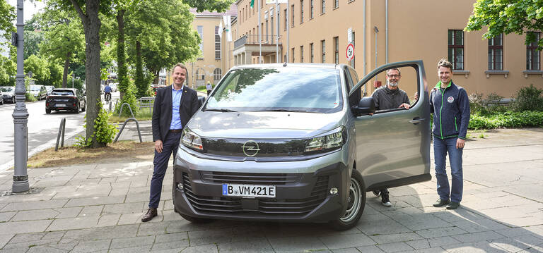 Bezirksstadtrat für Stadtentwicklung Patrick Steinhoff und Mitarbeitende des Vermessungsamtes Steglitz-Zehlendorf stellen das neue E-Fahrzeug vor. Foto: BA SZ