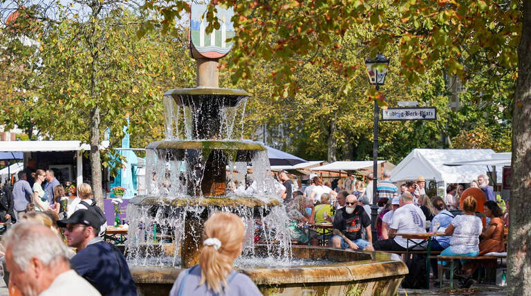 Gäste rund um den Wappenbrunnen am Ludwig-Beck-Platz, der vom 5. bis 7. September 2025 zum Weinbrunnen mutiert. Foto: André Ballin / Family & Friends e. V.