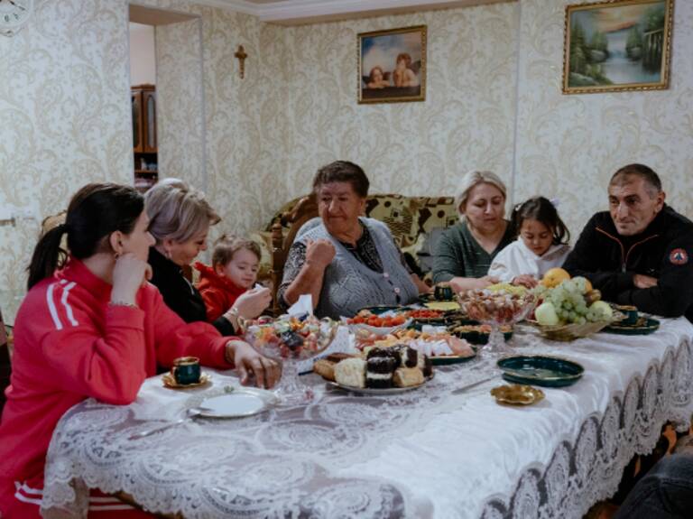 In einer Grenzstadt unweit von Aserbaidschan versucht eine Familie, trotz der latenten Bedrohung ihre tägliche Routine bei Kaffee und Kuchen aufrechtzuerhalten, während die Nähe zur Grenze allgegenwärtig bleibt und ständige Wachsamkeit erfordert. Jermuk, Armenien, 2024, Foto: Jana Islinger