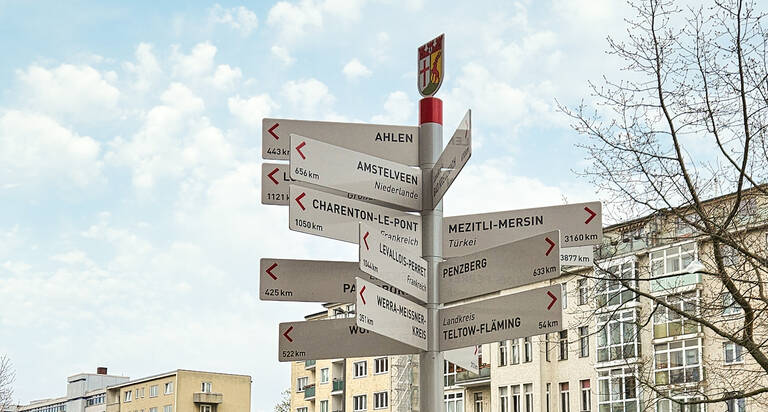 Wegweiser zu den Partnerstädten von Tempelhof-Schöneberg vor dem Rathaus Schöneberg.