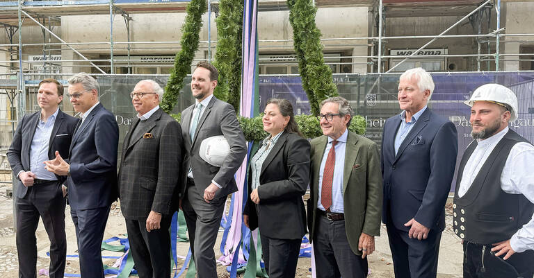 BAUWERT AG feiert Richtfest für ,Das Rheingau‘ in Berlin-Friedenau. V.l.n.r. vor der Richtkrone: Daniel Herrmann (Vorstand der BAUWERT AG), Jörn Oltmann (Bezirksbürgermeister des Bezirks Tempelhof-Schöneberg), Dr. Jürgen Leibfried (Gründer, Gesellschafter und Vorstand der BAUWERT AG), Alexander Slotty (Staatssekretär in der Senatsverwaltung für Bauen und Amtschef der Senatsverwaltung für Stadtentwicklung, Bauen und Wohnen), Eva Majewski Sparacino (Bezirksstadträtin und Leiterin der Abteilung Stadtentwicklung und Facility Management des Bezirksamts Tempelhof-Schöneberg), Michael Staudinger (Gesellschafter und Vorstand der BAUWERT AG), Siegfried Wik (Geschäftsführender Gesellschafter der BONANNI Gesellschaft von Architekten mbH) und Dennis Duda (Polier). Foto: BAUWERT AG
